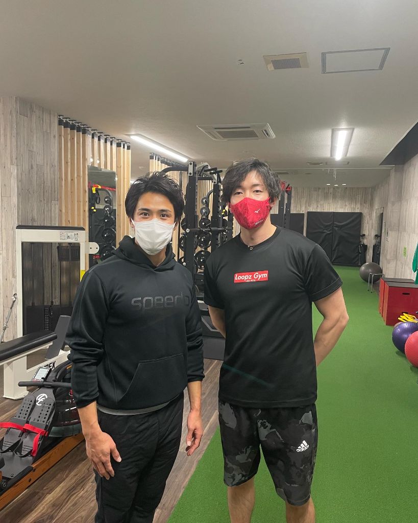 サイン入りユニフォームを持つスタッフ
