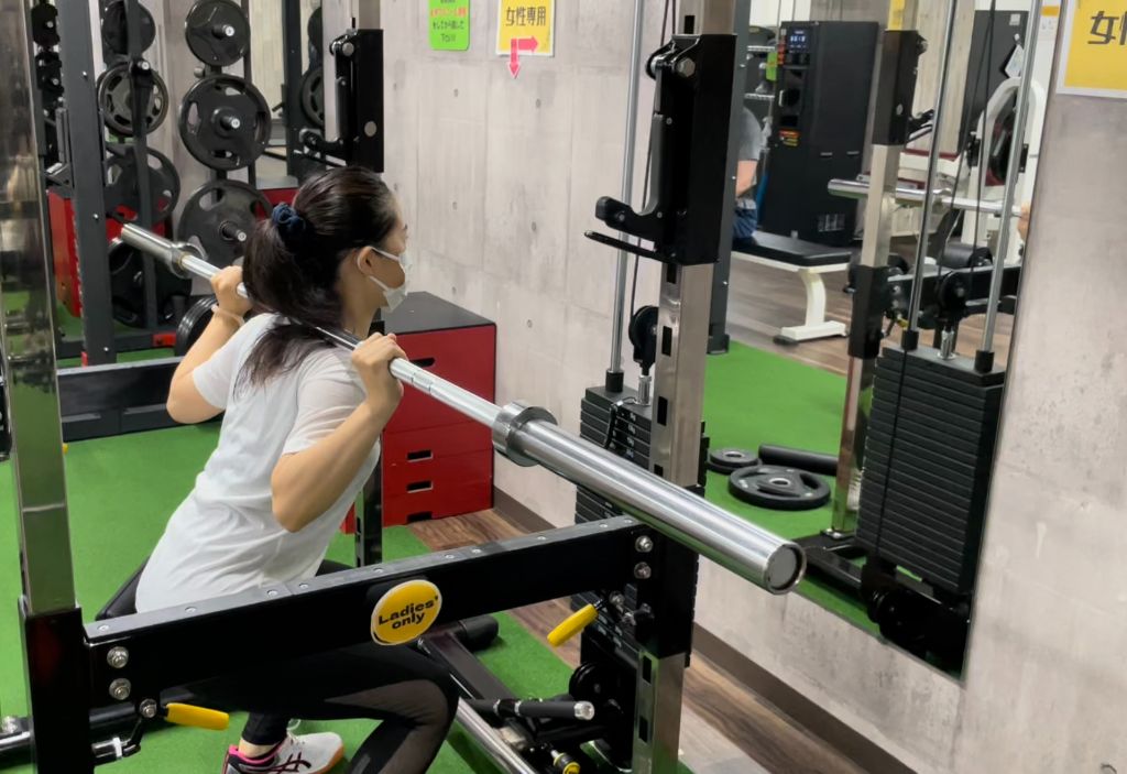 女性専用エリアでバーベルスクワットをする女性会員